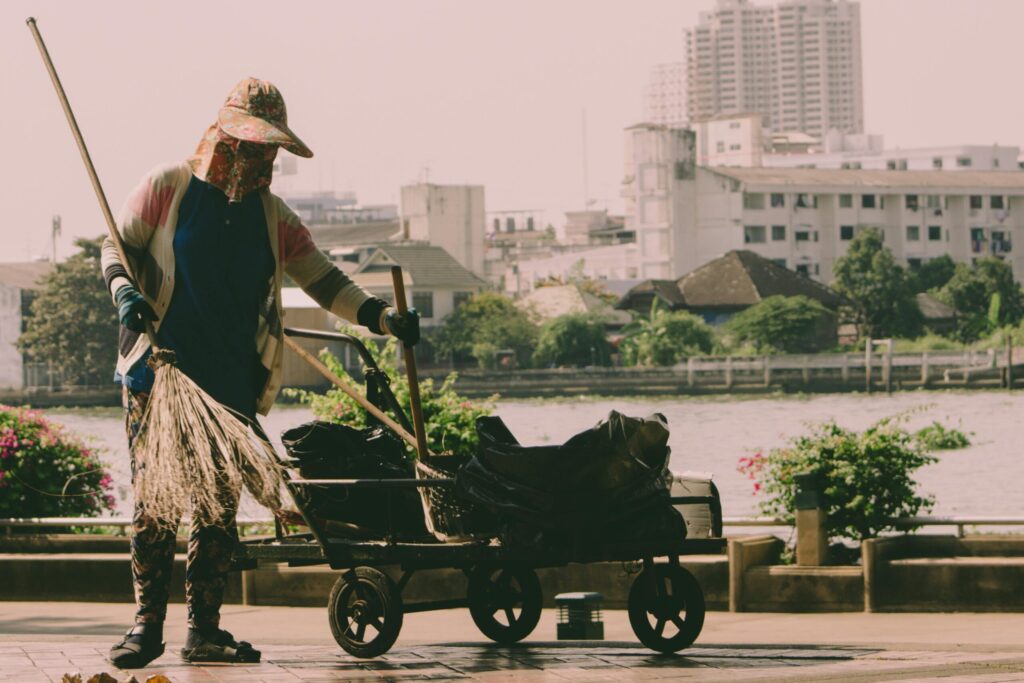 Worker sweeping beside a cart