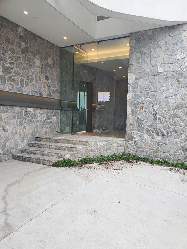 Stone-clad entrance with glass doors